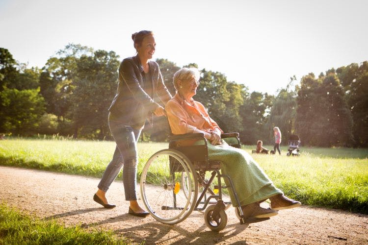 person walking with someone in a wheelchair